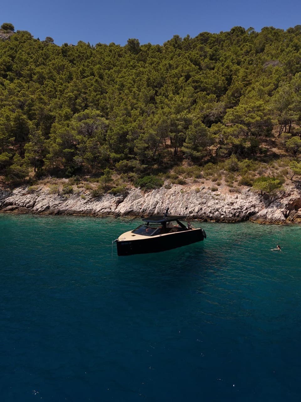Colnago 35 anchored in a turquoise cove near Split, a guest swimming alongside