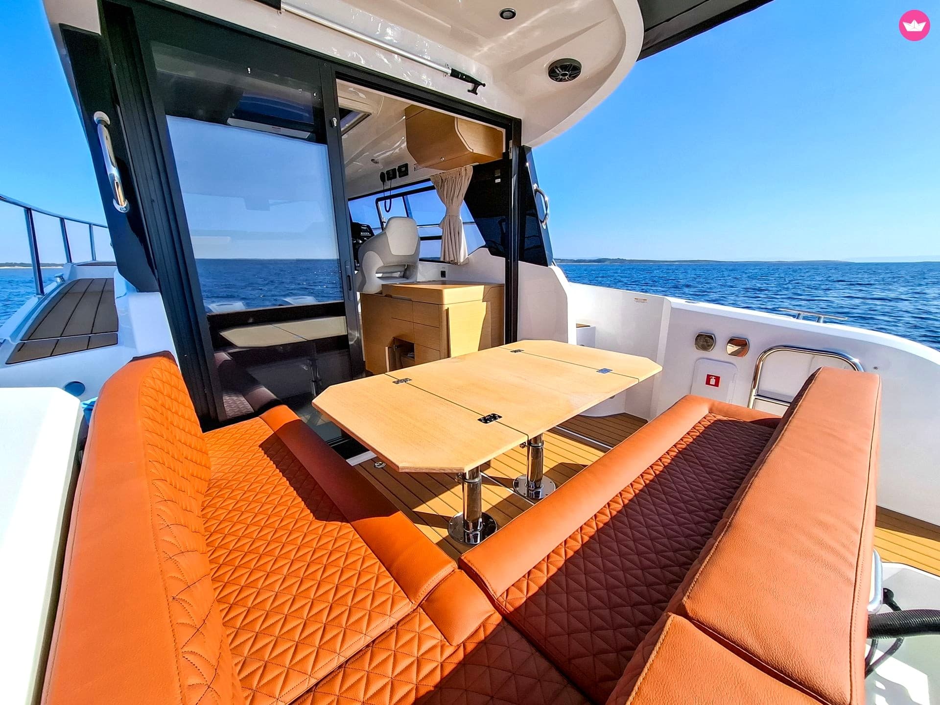 The Kavi's teak cockpit seating at anchor in a quiet bay, clear water alongside